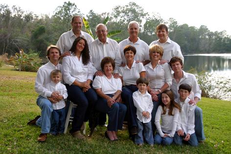 Family reunion. Large family of 14 people in white shirts and denim jeans outside. Dreamstime/TCA
