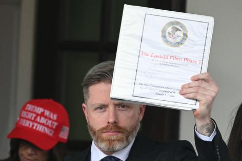 Political commentator Rogan O’Handley, aka DC Draino, and other unidentified people carrying binders bearing the seal of the U.S. Justice Department reading “The Epstein Files: Phase 1” walk out of the West Wing of the White House in Washington, D.C., on Feb. 27, 2025. The Trump administration has said it would release documents on late tycoon and convicted sex trafficker Jeffrey Epstein, who was found dead in his prison cell in 2019. (Saul Loeb/AFP via Getty Images/TCA)