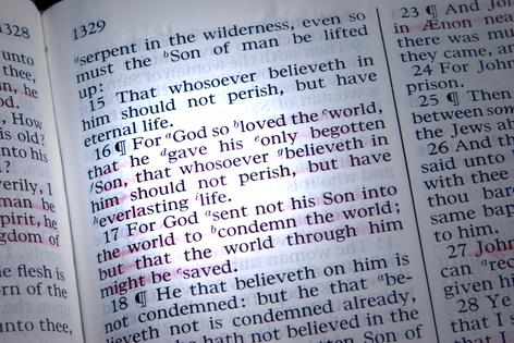 Bible is opened to John 3:16, highlighted by a beam of light. Dreamstime/TCA