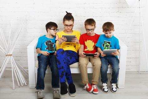 Children obsessed with their electronic devices. Dreamstime/TCA