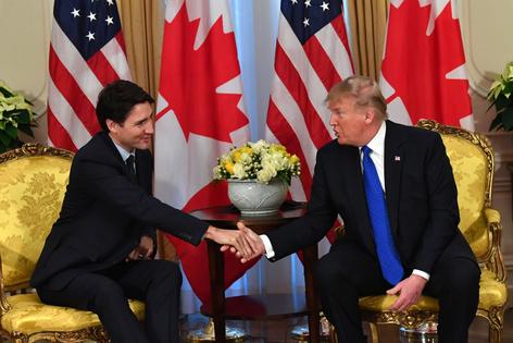 U.S. President Donald Trump (R) shakes hands with Canada’s Prime Minister Justin Trudeau during a meeting at Winfield House, London, on Dec. 3, 2019. (Nicholas Kamm/AFP via Getty Images/TCA)