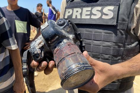A journalist holds the blood-covered camera belonging to Palestinian photojournalist Mariam Dagga, a journalist who freelanced for AP since the start of the war and who was killed in an Israeli strike on Nasser hospital in Khan Yunis in the southern Gaza Strip, during her funeral on August 25, 2025. Gaza's civil defence agency said five journalists, including Mariam Dagga, were among at least 20 people killed on August 25 when Israeli strikes hit Nasser hospital in the south, with Reuters, the Associated Press and Al Jazeera mourning their slain contributors. (Photo by AFP). AFP via Getty Images