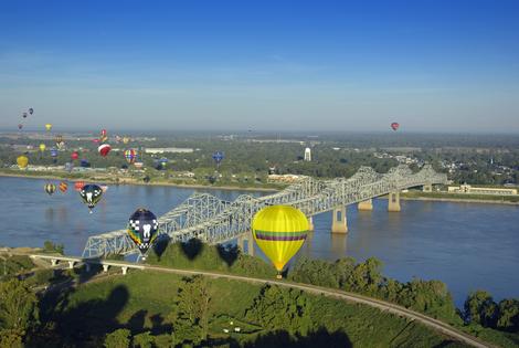 Hot Air Balloons Over Mississippi River. Hot air balloons flying over the Mississippi River toward Louisiana at Natchez, MS. Dreamstime/TCA