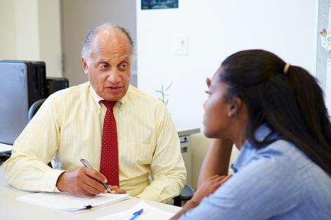 Student talking to counselor. Dreamstime/TCA