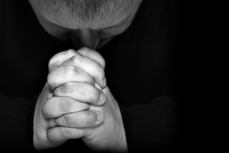 Man praying. Dreamstime/TCA