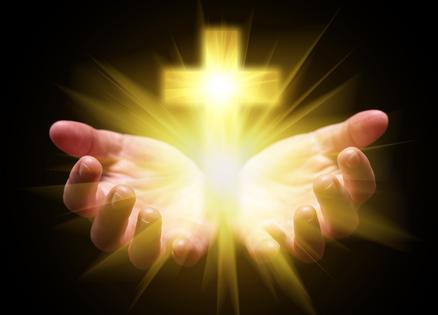 Hands cupping cross. Dreamstime/TCA