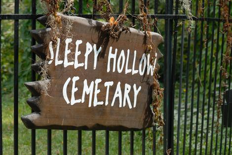 Painted wooden Sleepy Hollow cemetery sign on railings. Dreamstime/TCA