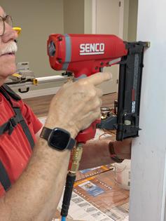 I’m using one of my favorite tools of all time: a pneumatic gun that fires thin finish nails and countersinks them too! (Tim Carter/Tribune Content Agency)