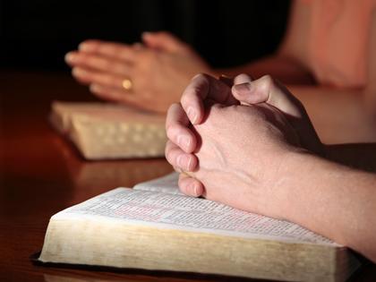 Man, woman, praying with Bibles. Dreamstime/TCA