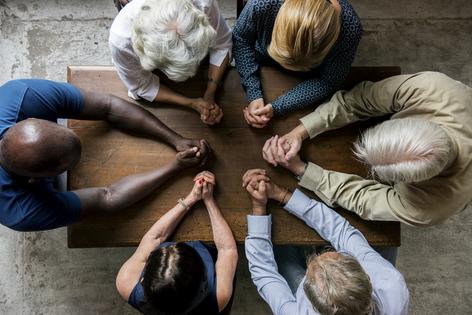 Group of people praying. Dreamstime/TCA