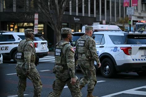 National Guard soldiers gather near a crime scene after a shooting in downtown Washington, DC, on November 26, 2025. Two members of the National Guard were shot Wednesday just blocks from the White House, according to officials, as a spokesperson for Donald Trump said the president has been briefed on the 