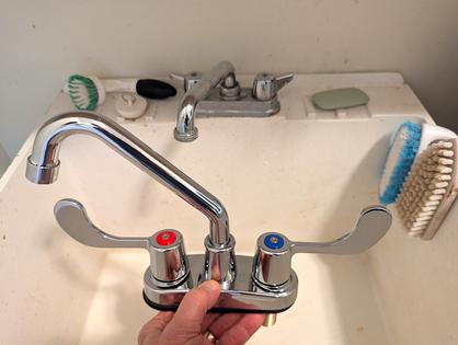 Tim Carter is holding a new laundry tray faucet with paddle handles. You can install one yourself in less than 30 minutes with a few inexpensive tools. (Tim Carter/Tribune Content Agency)