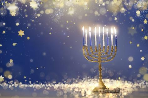 Happy Hanukkah. Candles lit in menorah. Family celebration of Jewish holiday. Getty Images