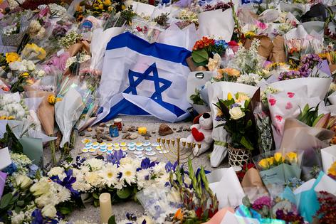 SYDNEY, AUSTRALIA - DECEMBER 15: An Israeli flag and flowers are laid outside Bondi Pavilion at Bondi Beach as people gather to mourn in the wake of a mass shooting on December 15, 2025 in Sydney, Australia. Police say at least 16 people, including one suspected gunman, were killed and more than a dozen others injured when two attackers opened fire near a Hanukkah celebration at the world-famous Bondi Beach, in what authorities have declared a terrorist incident. (Photo by Audrey Richardson/Getty Images)