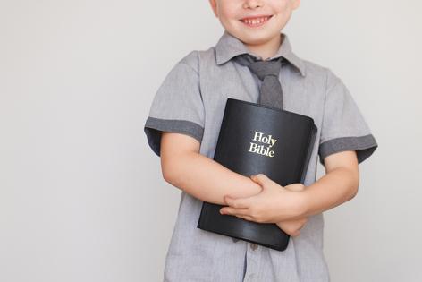 Boy holding Holy Bible. Dreamstime/TCA