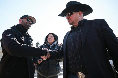 Enrique Tarrio, left, former leader of the far-right group the Proud Boys, shakes hands with Oath Keepers founder Stewart Rhodes in Washington on Feb. 21, 2025.  Chip Somodevilla/Getty Images