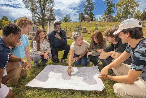 The author and students from her advanced GIS course investigate paper maps of the cemetery.
              Miami University Communications, CC BY-ND
