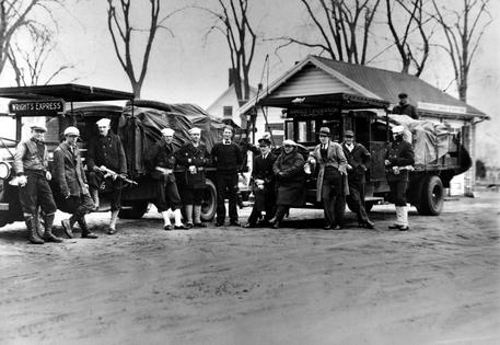 Coast Guardsmen stand in front of two truckloads of liquor seized on April 14, 1931, after a battle between three policemen and several alcohol smugglers near Falmouth, Mass. AP Photo