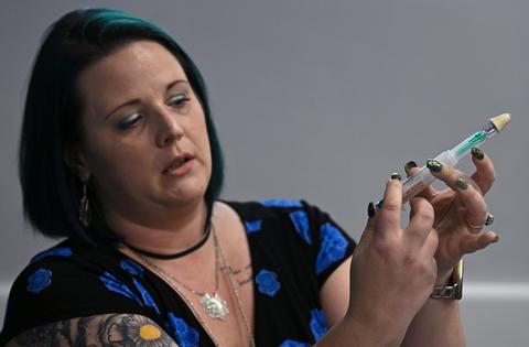 Rachel Lambert, a recovering heroin user, demonstrates how to administer naloxone.
              Michael S. Williamson/The Washington Post via Getty Images