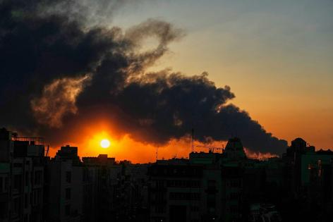 The sun sets behind a plume of smoke rising after a U.S.-Israeli military strike in Tehran, Iran, on March 3, 2026.
              AP Photo/Vahid Salemi