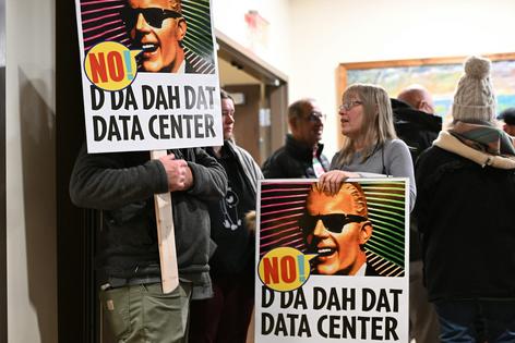 People opposed to a data center proposal at the former Pennhurst state hospital grounds talk during a break in an East Vincent Township supervisors meeting in December 2025 in Spring City, Pa.
              AP Photo/Marc Levy, file