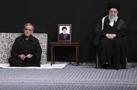 Iranian President Masoud Pezeshkian, left, sits next to Supreme Leader Ayatollah Ali Khamenei in a mourning ceremony on July 12, 2024.
              Office of the Iranian Supreme Leader via AP