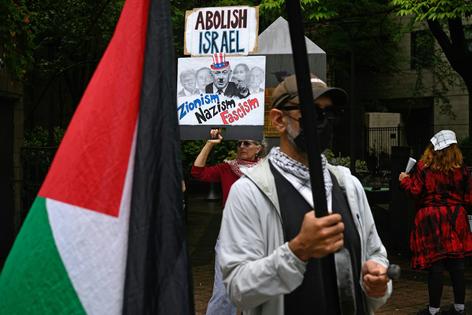 A woman holds signs that depict Israeli leader Benjamin Netanyahu with a Hitler mustache at a protest outside the U.N. on Sept. 25, 2025, in New York.
              Alexi J. Rosenfeld/Getty Images
