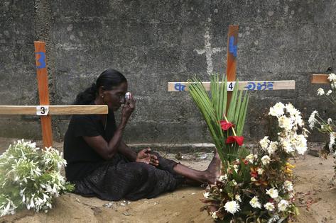 A relative of a victim of the Easter bombings prays at their burial site in Negombo, Sri Lanka, on April 28, 2019.
              AP Photo/Manish Swarup