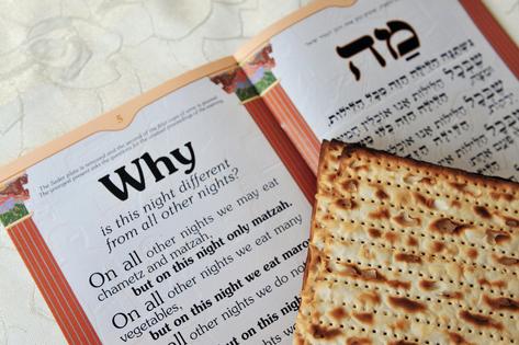 Passover Matzo Sheet and Haggadah. Traditional Jewish Matzo sheets on a Passover Seder table. Dreamstime/TCA