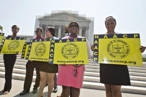 Representatives from the NAACP stand outside the Supreme Court on June 25, 2013, awaiting a decision in Shelby County v. Holder. AP Photo/J. Scott Applewhite