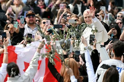 Pope Leo XIV greets the crowd as he leaves after the Palm Sunday mass at St Peter's square in the Vatican on March 29, 2026. (Photo by Tiziana FABI / AFP via Getty Images)