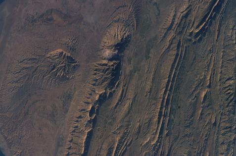 A satellite view of an area of the southwestern Zagros Mountains shows long ridges and valleys, evidence of tectonic plates colliding.
              NASA via Flickr