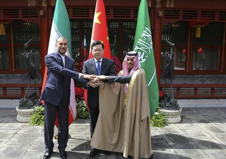 China’s former foreign minister looks on as Iranian and Saudi diplomats shake hands during Beijing-mediated talks in 2023.
              Iranian Foreign Ministry via AP