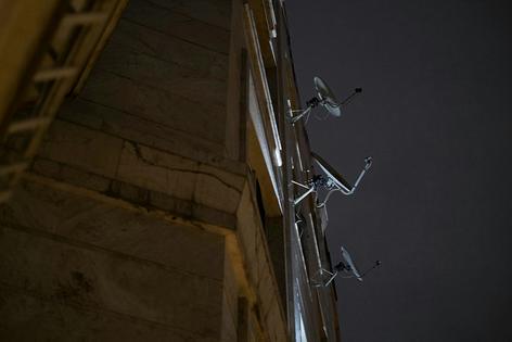 Satellite dishes hang from a housing complex in Tehran on March 29, 2026, amid U.S.-Israeli military operations in the region. Morteza Nikoubazl/NurPhoto via Getty Images