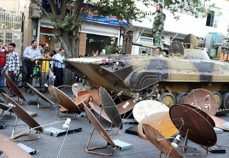 A picture from Iran’s ISNA news agency shows soldiers destroying satellite dishes with an army tank in Shiraz on Sept. 28, 2013.
Mohsen Tavaro/ISNA News Agency/AFP via Getty Images