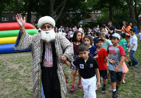 A man wearing a Nasreddin Hoja costume poses with children during Eid al-Fitr at Sunnyside Gardens Park in New York. Volkan Furuncu/Anadolu via Getty Images