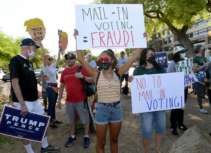Victoria Beraja, center, and her mother, Lisa Burgess, right, both of Nevada, protest the passage of a mail-in voting bill during a Nevada Republican Party demonstration at the Grant Sawyer State Office Building on Aug. 4, 2020, in Las Vegas.
              Getty Images