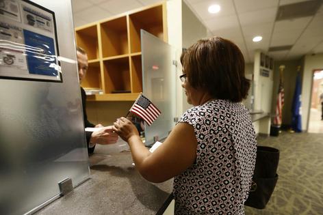 A woman receives a U.S. flag after passing her citizenship interview in Newark, N.J., on May 25, 2016.
              AP Photo/Julio Cortez