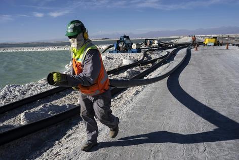 Workers perform maintenance at pools where evaporation concentrates lithium-rich brine in Chile’s Atacama Desert in 2023. To extract lithium, mines pump water from beneath the salt flats.
              AP Photo/Rodrigo Abd