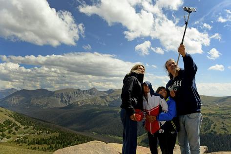 A family poses for a selfie in front of the Gore Range overlook in Rocky Mountain National Park in Colorado. The park saw 4.2 million visitors in 2024.
              Helen H. Richardson/The Denver Post via Getty Images