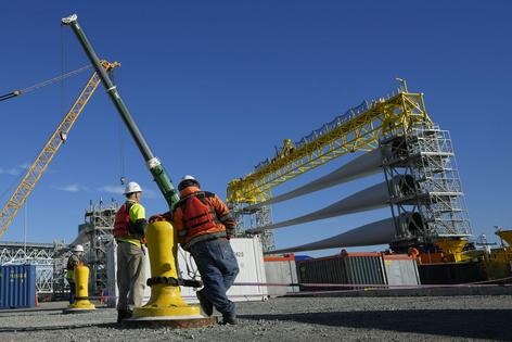 Workers in New London, Conn., prepare a generator and its blades for transport to South Fork Wind’s offshore wind farm in 2023. To build an offshore wind farm requires manufacturing jobs, parts suppliers, dockworkers, crane operators, ship crews, as well as the wind farm construction crews and maintenance teams and many more businesses and their employees.
              AP Photo/Seth Wenig