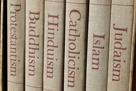 Book spines listing major world religions - Judaism, Islam, Catholicism, Hinduism, Buddhism and Protestantism. Dreamstime/TCA