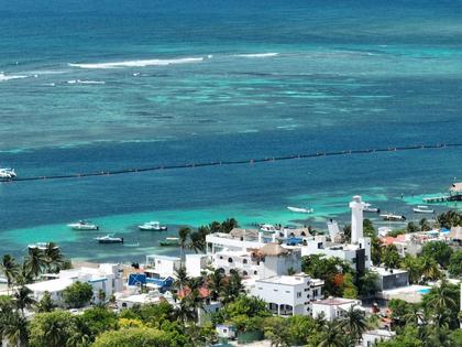 Reefs visible just offshore protect the coastline of Puerto Morelos, Mexico, in part by breaking waves during storms.
              Lorenzo Alvarez-Filip