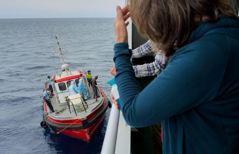 Passengers on the the hantavirus-stricken cruise ship MV Hondius watch epidemiologists board the boat in Praia, Cape Verde, on May 6, 2026 AP Photo/Uncredited