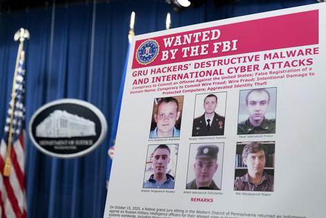 A Department of Justice poster shows six GRU officers charged with cyberattacks, Oct. 19, 2020.
Andrew Harnik/Pool via Getty Images