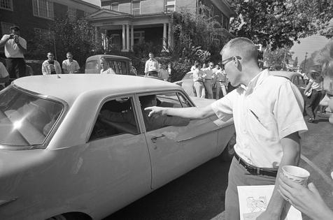 A University of Mississippi student points a finger at James Meredith as he is taken to class, in Oxford, Miss., on Oct. 4, 1962.
              AP Photo