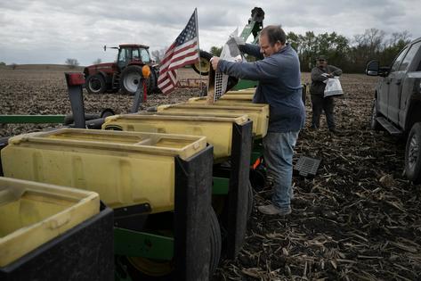 Alan Montag, a third-generation Iowa farmer, and his son Aden load soybean seed into a planter on May 6, 2026. Scott Olson/Getty Images
