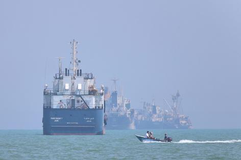 A small motorboat passes anchored vessels in the Strait of Hormuz off Bandar Abbas, Iran, on June 11, 2026. Amirhosein Khorgooi/ISNA via AP