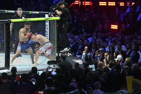 U.S. President Donald Trump, right, watches the lightweight title bout between Georgia's Ilia Topuria and America's Justin Gaethje during the "UFC Freedom 250" mixed martial arts event on the South Lawn of the White House on June 15, 2026, in Washington, D.C. (Saul Loeb/Pool/Getty Images/TNS)