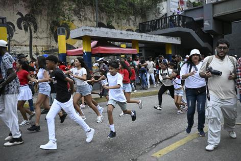 People run into the streets to get away from buildings as an earthquake shakes Caracas on June 24, 2026.
              Federico Parra/AFP via Getty Images